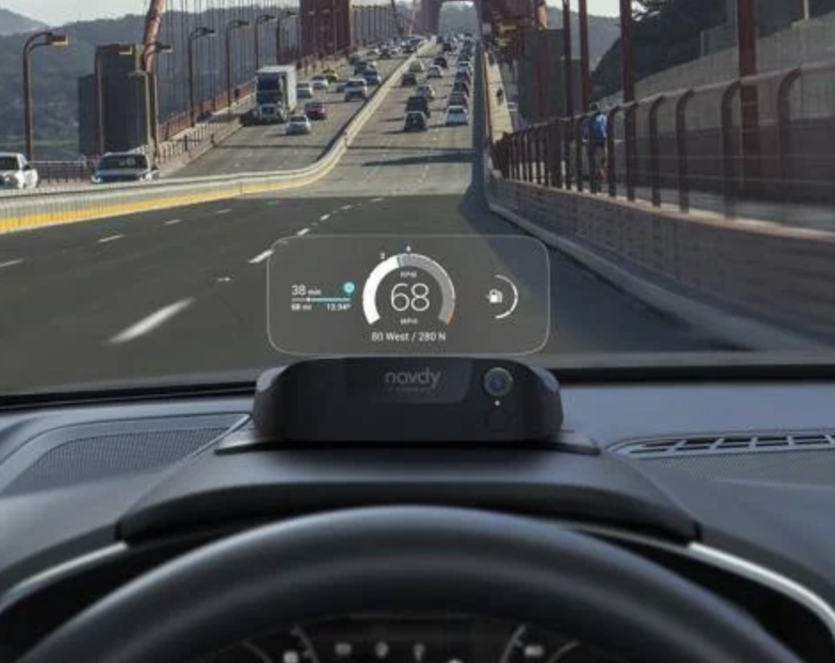 Image of a head up display mounted in a car, with traffic visible through it